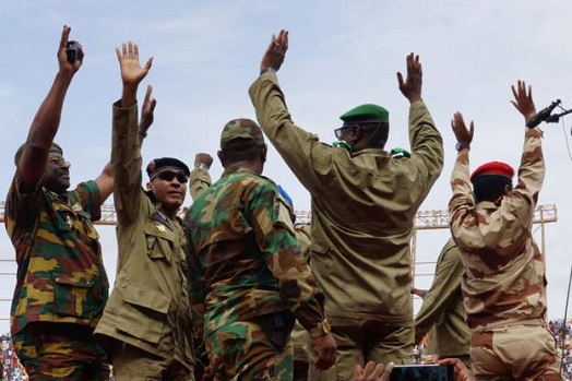 Mohamed Toumba (second from right) and other junta members hail coup supporters at a stadium in the capital at the weekend